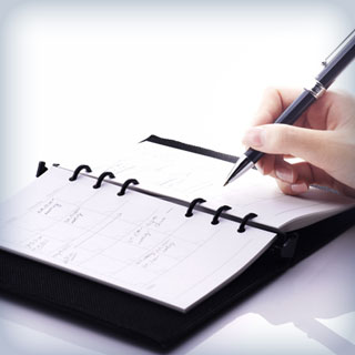 person getting ready to write in scheduling book